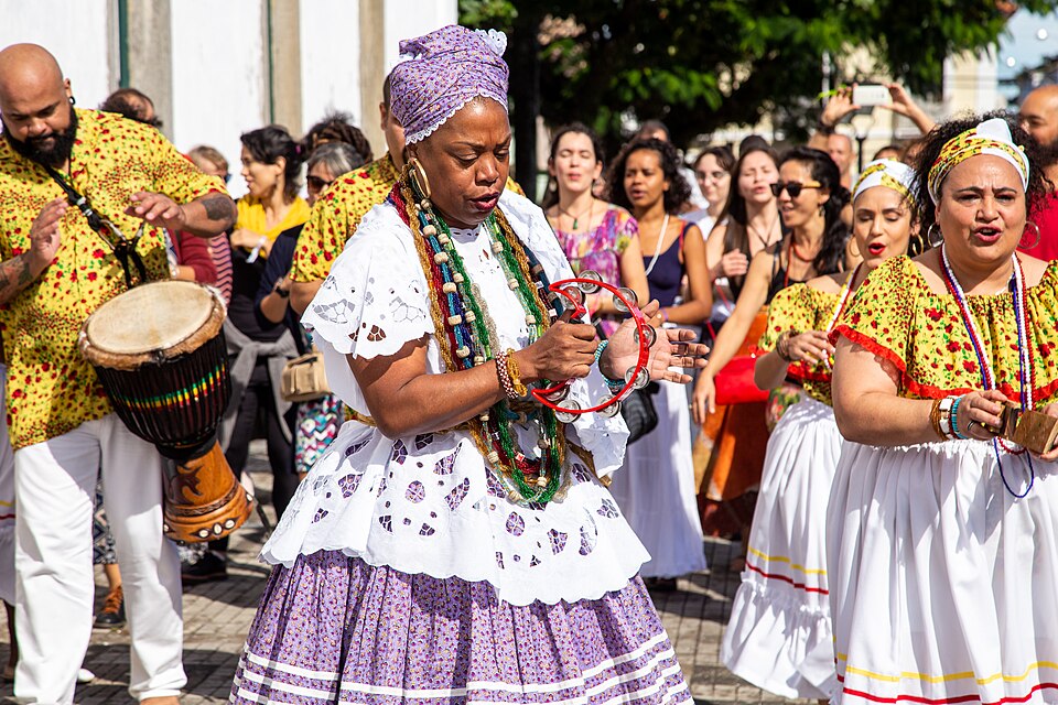 Mulheres tocando, cantando e marcando o ritmo em uma roda de samba